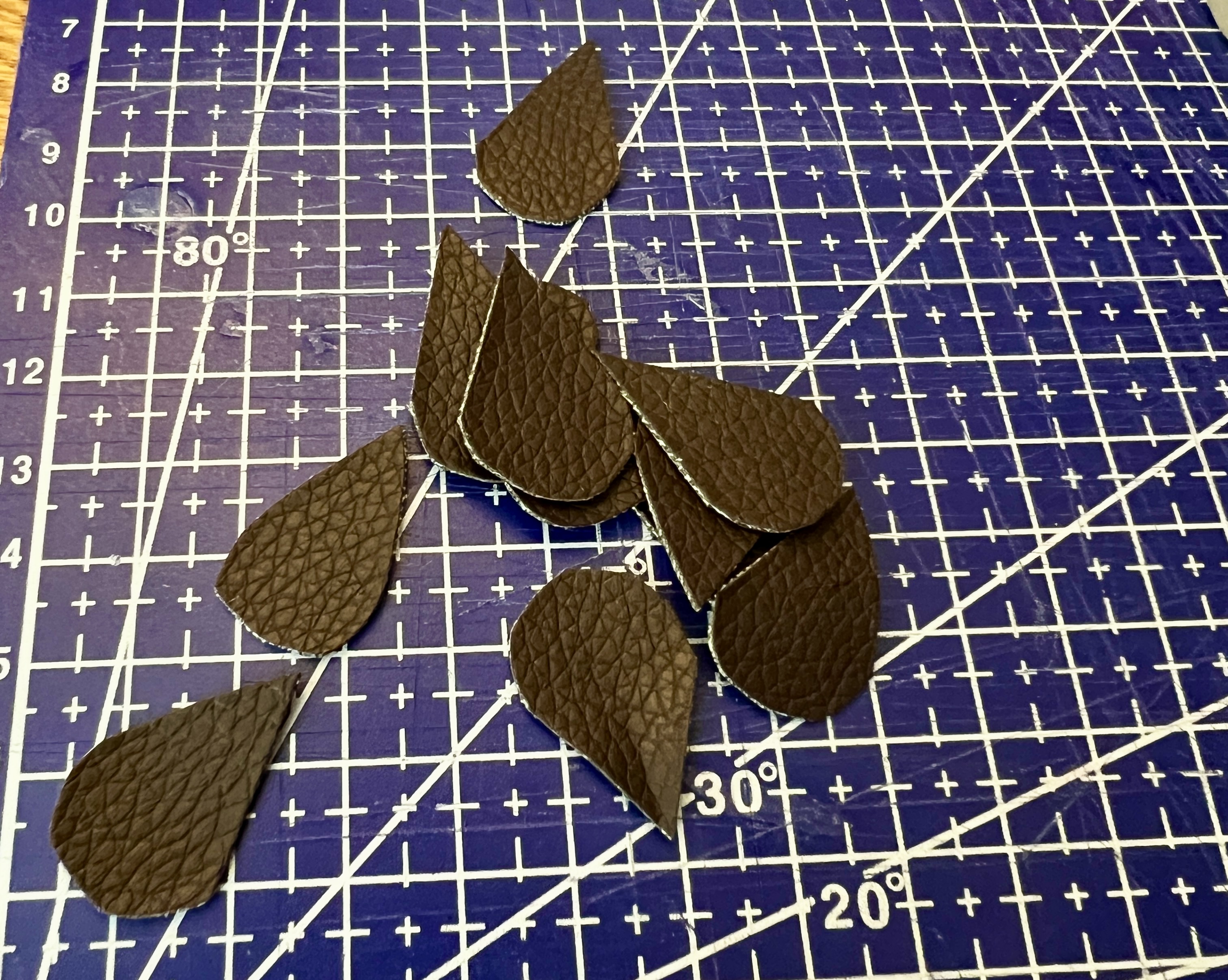 Teardrop-shaped pieces of pleather cut out as ears for the wooden mice